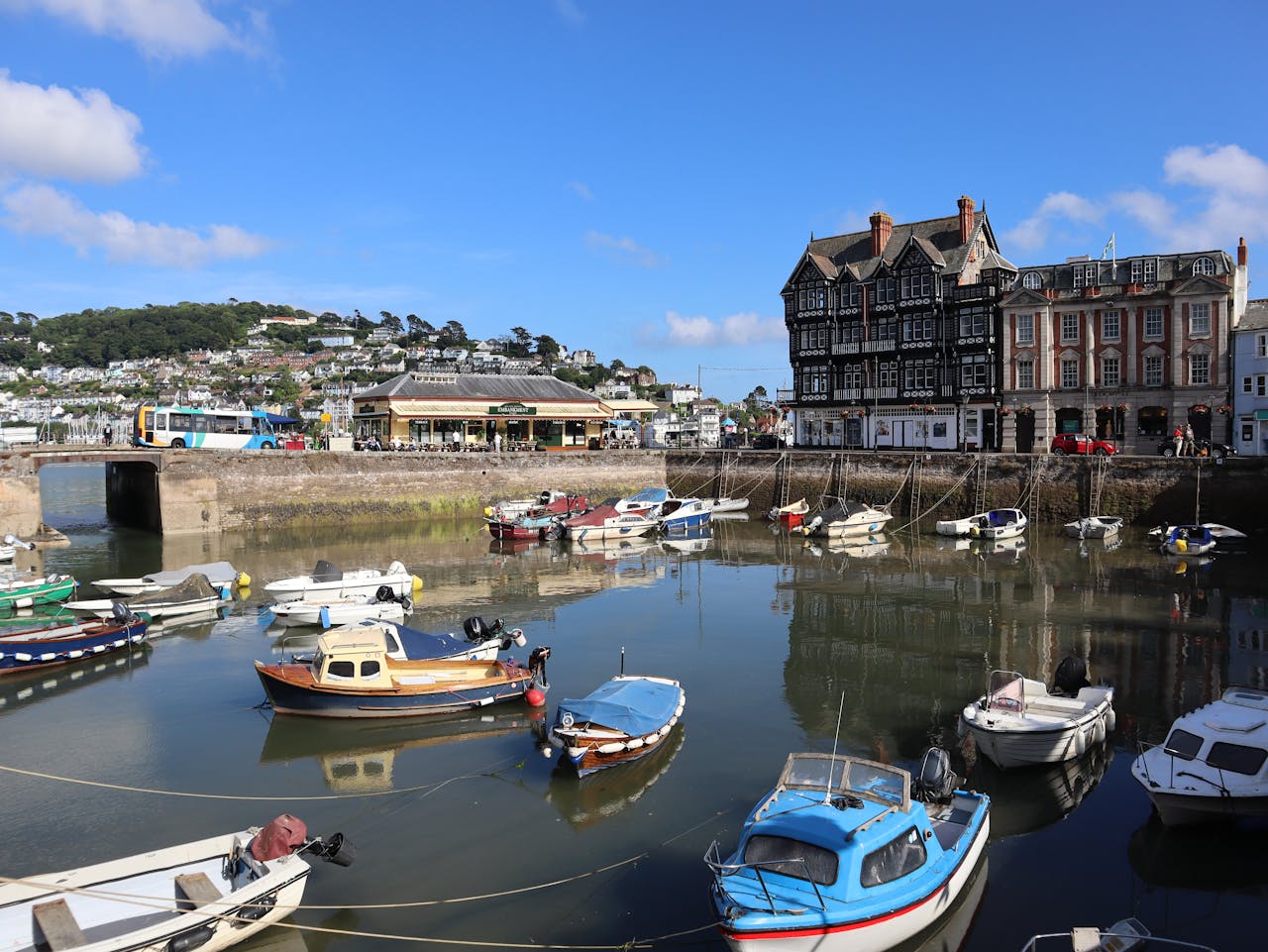 Charming harbor view in Dartmouth, England with moored boats and historic buildings.